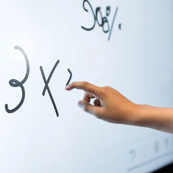 Close-up of child's hands writing on the i3CONNECT Elm 2