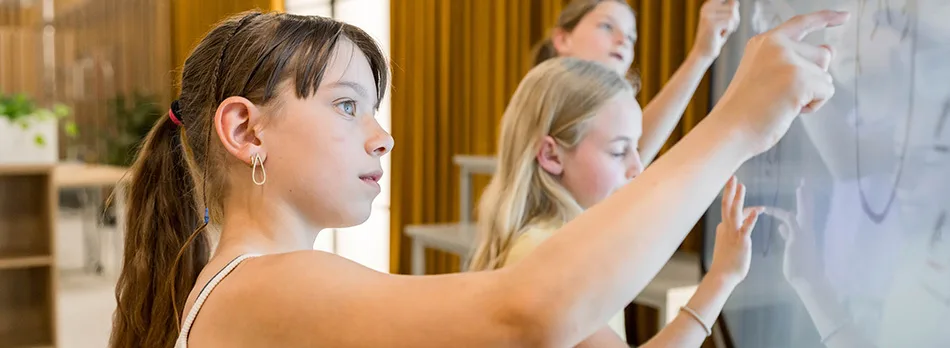 Three girls writing on the i3CONNECT Elm 2