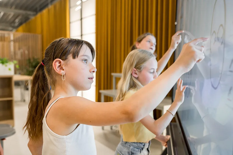 Three girls writing on the i3CONNECT Elm 2